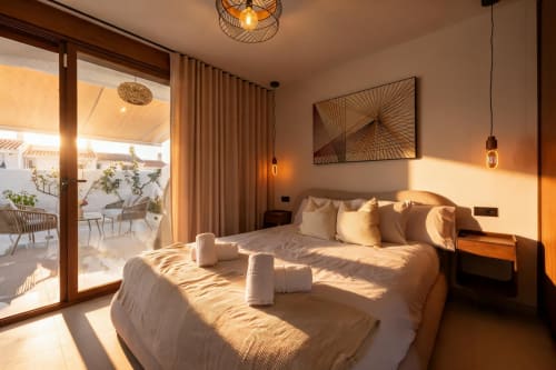 Lujosa habitación de villa en Nerja con vistas al mar, cama king, decoración moderna, acceso a terraza e iluminación natural cálida