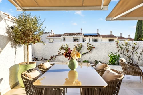 Terraza de villa de lujo en Nerja con mesa de comedor, vistas al mar, casas encaladas y toldo retráctil