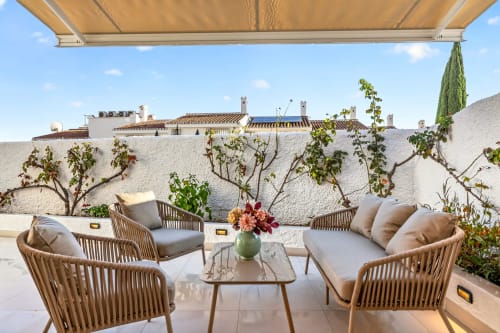 Terraza de lujo con vistas al mar en Villa Mandarinos, Nerja, con sillas tejidas, flores y encalado