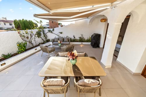 Terraza de villa de lujo en Nerja con mesa de comedor, área de descanso, toldo retráctil y vistas al mar