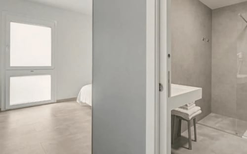 Modernes Badezimmer im Hotel Ca'Tron in Dolo mit begehbarer Dusche, weißem Waschbecken und Blick ins Schlafzimmer