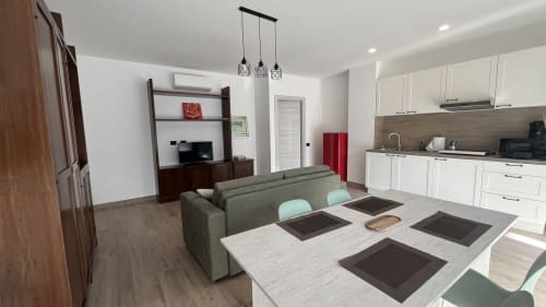 Moderno appartamento open-plan a Tolstoi 13.15 a Saronno con zona pranzo, cucina, soggiorno e mobile intrattenimento