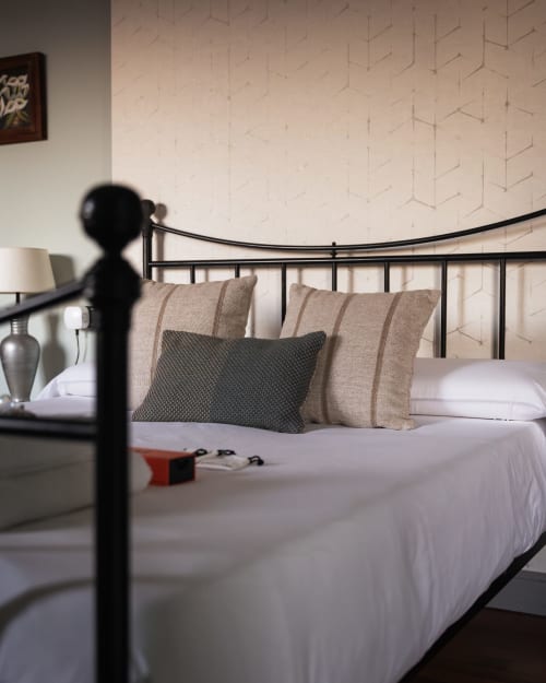 Elegantly designed bedroom at Casa Señorial Sasueta in San Sebastián with metal bed frame and neutral bedding