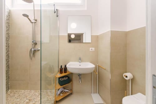 Bagno moderno nella Lake Room della Provincia di Verona B&B con doccia a filo parete, lavabo sospeso, specchio e mobile in legno