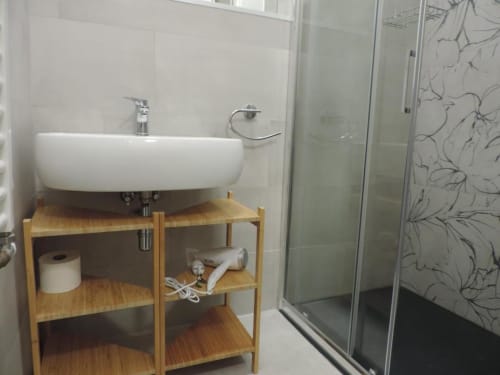 Bagno moderno nella Camera Colli di Provincia di Verona B&B con lavabo bianco curvo, mobile in legno e doccia walk-in