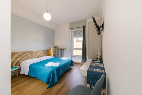 Camera Lake Room con biancheria blu, testata in legno, TV e vista sulla corte interna presso Provincia di Verona B&B