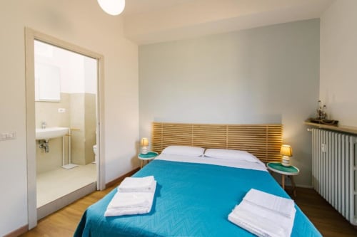 Camera Lake Room con biancheria blu, testata in legno, bagno privato e vista sulla corte interna a Provincia di Verona