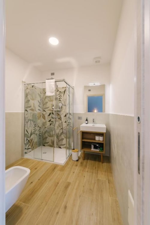 Bagno moderno con doccia walk-in, mobile in legno, wc e pavimento effetto legno presso Provincia di Verona B&B