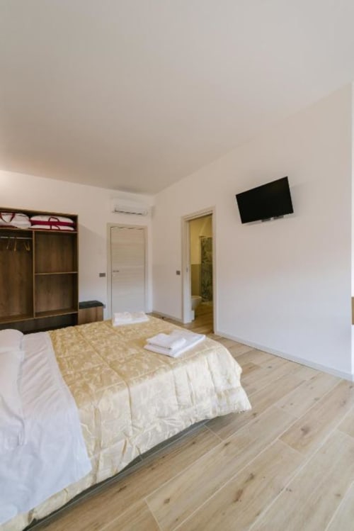 Camera moderna con due letti singoli, pavimenti in legno, armadio, TV e bagno privato presso il B&B Provincia di Verona in Italia