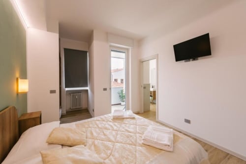 Camera moderna nel B&B di Verona con letto, TV a schermo piatto, accesso al balcone e vista sui monumenti