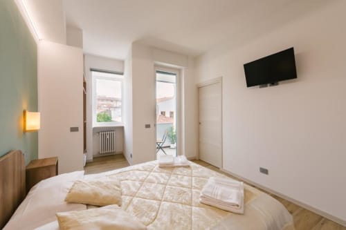 Camera moderna in Camera Olivo, B&B a Verona, con letto matrimoniale, TV schermo piatto, accesso al balcone e vista sui monumenti della città
