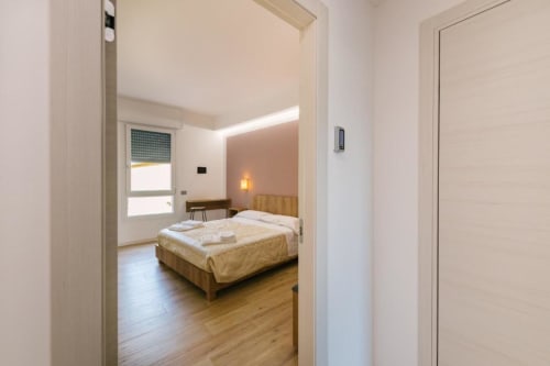 Camera da letto moderna con letto in legno, scrivania e finestra nella B&B di Verona. Stanza con vista sulla città e arredamento contemporaneo.