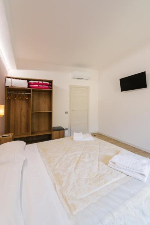 Camera moderna con armadio in legno, letti gemelli, TV, design minimalista presso B&B Provincia di Verona