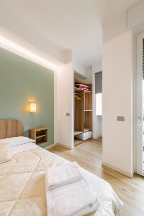 Camera moderna in Provincia di Verona B&B con letto matrimoniale, parete verde salvia, comodino in legno e guardaroba walk-in