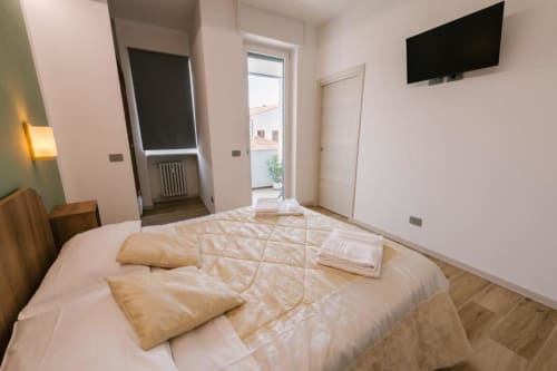 Camera Olivo a Verona B&B: moderna camera da letto con TV schermo piatto, balcone con vista sui monumenti e arredi contemporanei