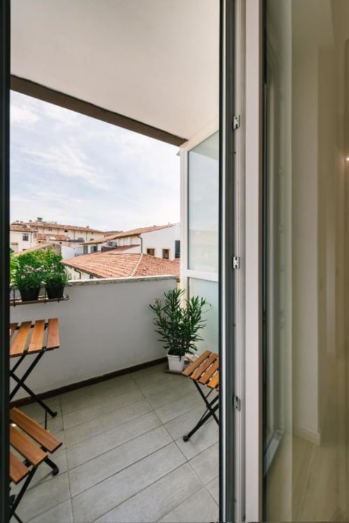 Terrazza balcone Camera Olivo con sedie in legno che affacciano sui tetti di Verona e gli edifici storici, Italia