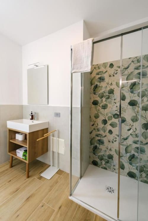 Bagno moderno nella camera Olivo del B&B Provincia di Verona con vanità in legno, lavabo bianco, specchiera e cabina doccia