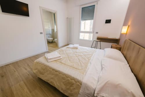 Camera matrimoniale moderna a Verona con parquet, bagno privato, TV a schermo piatto e vista sulla città