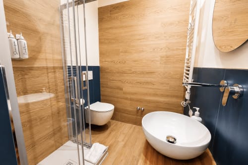 Bagno moderno nella suite Blu Palm di Le Rooms B&B, San Benedetto del Tronto, con pareti in legno, doccia walk-in e vasca ovale