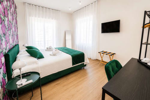 Camera moderna a Le Rooms B&B a San Benedetto del Tronto con letto in velluto verde, biancheria bianca e balcone con vista sulla città