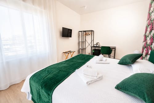 Camera moderna al Le Rooms B&B di San Benedetto del Tronto con letti gemelli, accenti in velluto verde, TV e balcone con vista sulla città
