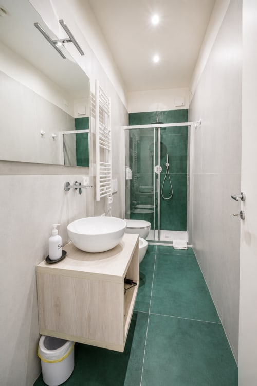 Bagno moderno presso Le Rooms B&B a San Benedetto del Tronto con vanity bianca, lavabo rotondo, doccia con piastrelle verdi e