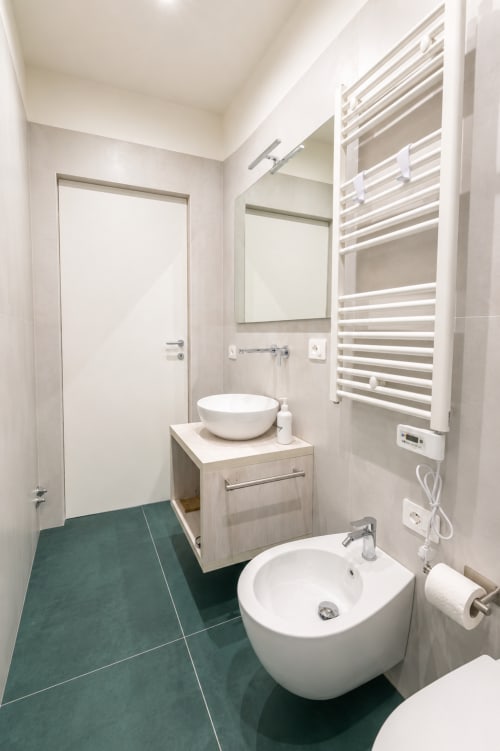 Bagno moderno presso Le Rooms B&B a San Benedetto del Tronto con lavabo bianco, wc sospeso e piastrelle teal
