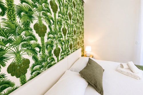 Camera accogliente presso Le Rooms B&B con carta da parati a motivi tropicali, biancheria bianca e vista sul giardino a San Benedetto del Tronto