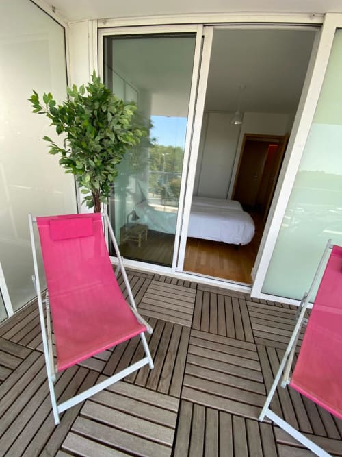 Chaises longues roses sur balcon en bois avec plante en pot, vue sur le lac de La Rochelle, appartement Centre Ville