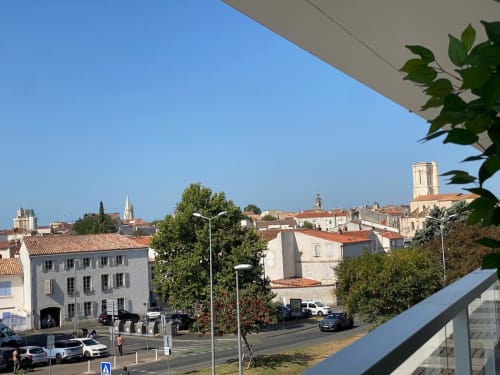 Vue du centre-ville de La Rochelle depuis le balcon avec ses bâtiments historiques et le clocher de l'église sous un ciel bleu dégagé