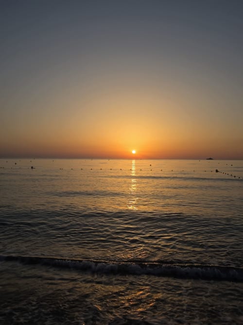 Coucher de soleil doré sur la Méditerranée à l'Hôtel Les Lauriers, plage de Saint-Tropez avec vagues douces