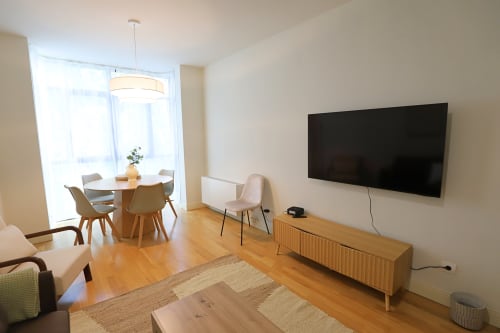 Apartamento moderno en Madrid Río con TV mural, comedor, muebles de madera y ventanales del piso al techo