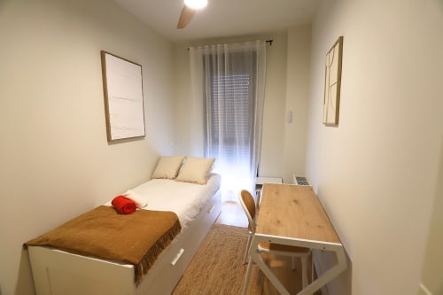 Luminosa habitación en Madrid Río con dos camas individuales, escritorio y amplia ventana con cortinas translúcidas