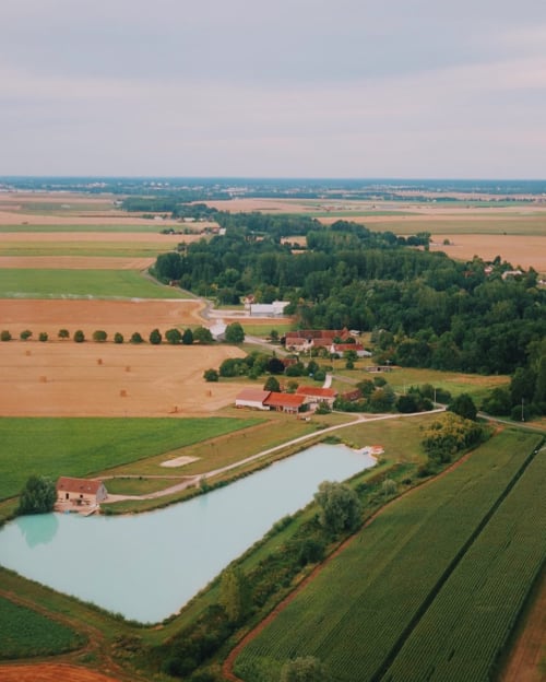 Aerial view of Les gîtes de Cormenin in Saint-Hilaire-sur-Puiseaux, French countryside with ponds and farmland