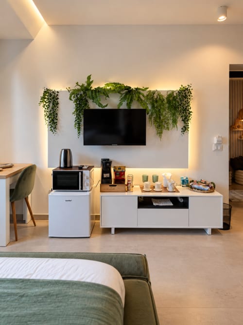 Suite Giardino Segreto presso Domus Fysi Palermo: camera moderna con TV a parete, piante sospese, mobile bianco per media e