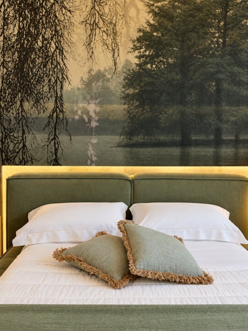 Elegante letto con testata rivestita in verde presso Domus Fysi Palermo, con cuscini bianchi e decorativi