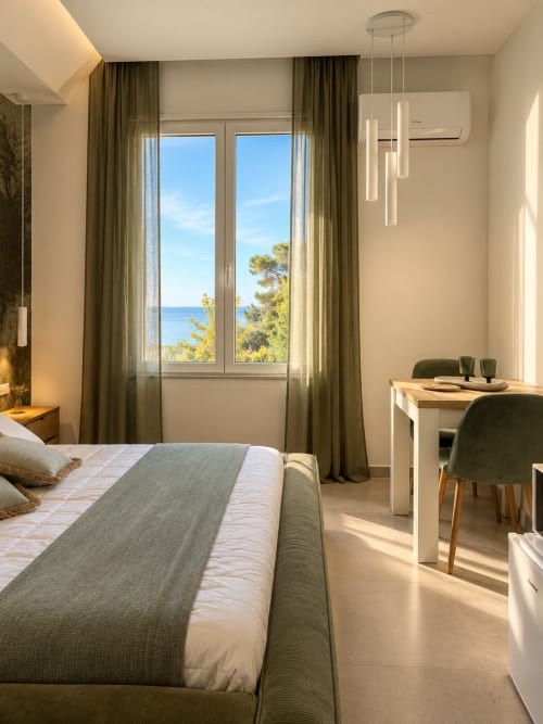 Camera Modern Suite Giardino Segreto di Domus Fysi Palermo con vista mare, letto, scrivania e aria condizionata