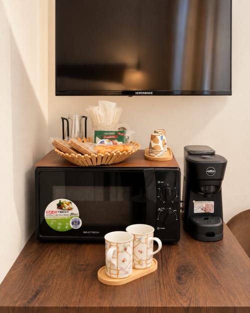 Angolo caffè in Suite Terra Eden presso Domus Fysi Palermo con microonde, caffettiera, tazze e pasticcini