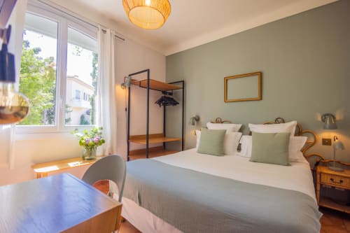 Chambre lumineuse à l'Hôtel Les Lauriers à Saint-Tropez avec lit queen-size, accents verts et baldaquin