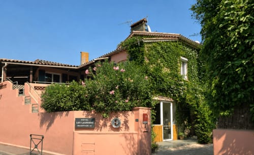 Hôtel Les Lauriers à Saint-Tropez : façade en terre cuite couverte de lierre, plantes grimpantes fleuries, charme méditerranéen