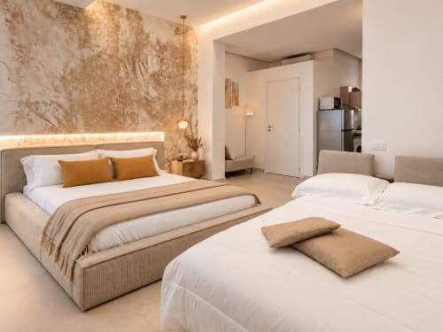 Suite moderna a Domus Fysi a Palermo con due letti, illuminazione calda, parete in rilievo e accesso al kitchenette