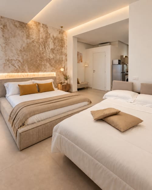 Suite camera moderna a Domus Fysi Palermo B&B con due letti, dettagli dorati, parete in marmo e illuminazione d'ambiente