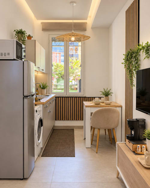 Cucina moderna di Domus Fysi Palermo con elettrodomestici in acciaio inossidabile, zona pranzo e balcone con vista mare