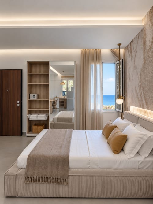 Camera suite moderna di Domus Fysi a Palermo con vista mare, letto con cuscini, scaffali in legno e balcone panoramico