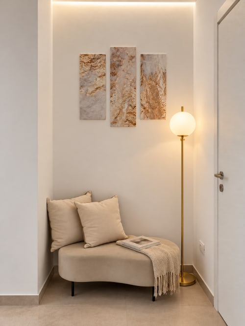 Accogliente angolo a Domus Fysi Palermo con sedute beige, lampada dorata e arte murale texturizzata