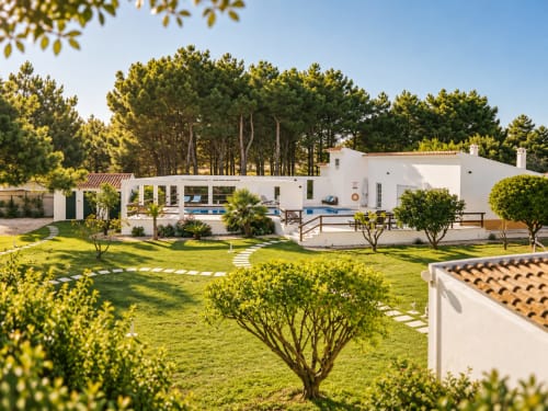 Hotel Vila Louro com arquitetura branca, vista para piscina, jardim cuidado e pinheiros em Santa Cruz, Portugal