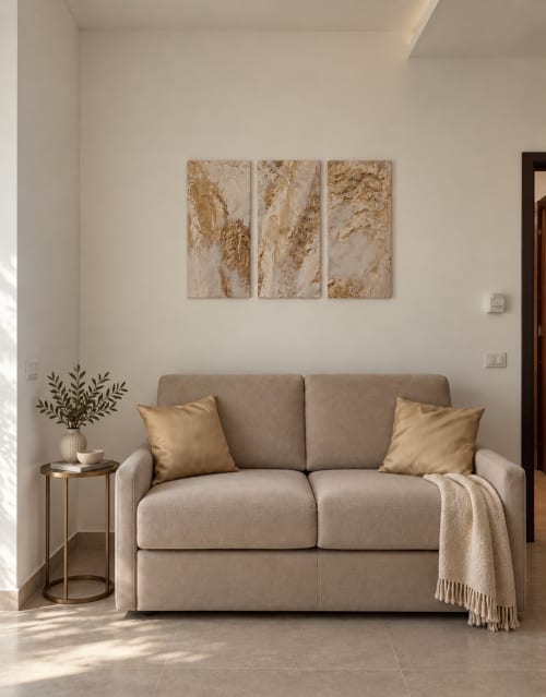 Soggiorno moderno della Domus Fysi B&B a Palermo con divano beige, cuscini dorati e arte astratta alle pareti