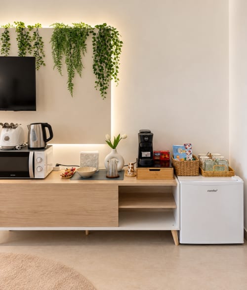 Angolo cottura moderno nella suite del B&B di Palermo con piante sospese, caffettiera, frigorifero compatto e cestini portaoggetti organizzati