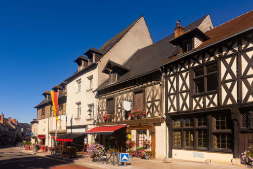 L'hôtel Les Maraîchades à Pierrefitte-sur-Sauldre propose de charmants bâtiments à colombages avec auvent rouge et fleurs