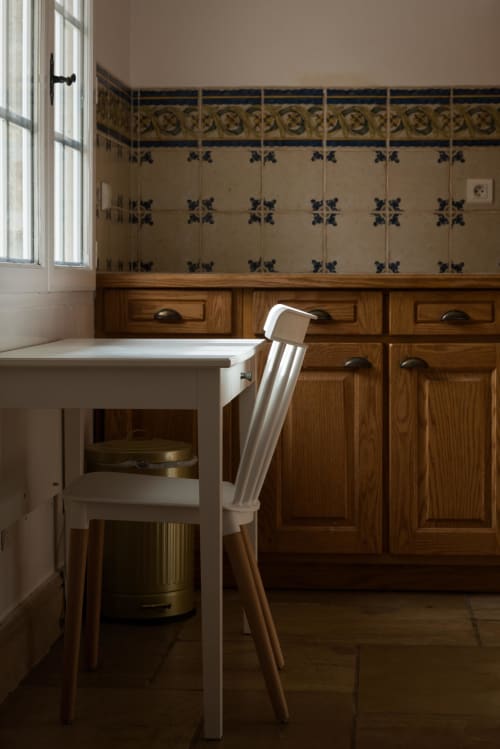 Cuisine rustique du gîte Domaine Chapelle avec évier blanc, meubles en bois et crédence en carrelage bleu à La
